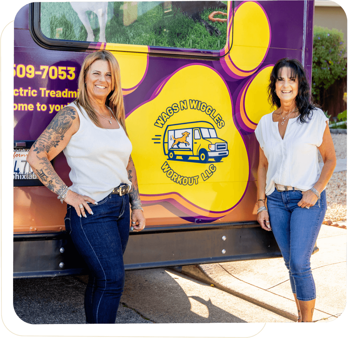 Two women standing by a colorful van.